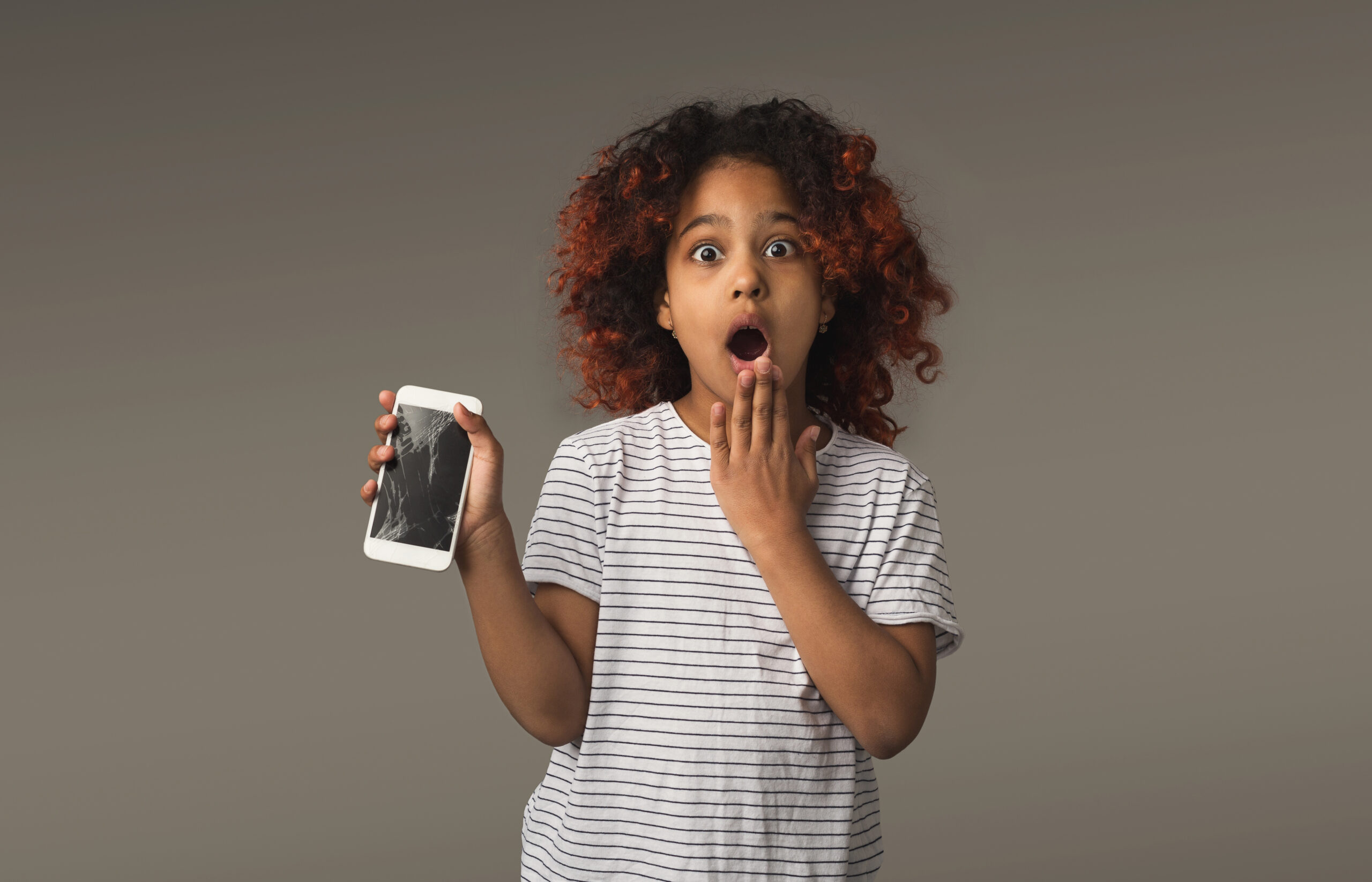 Young girl with broken smartphone