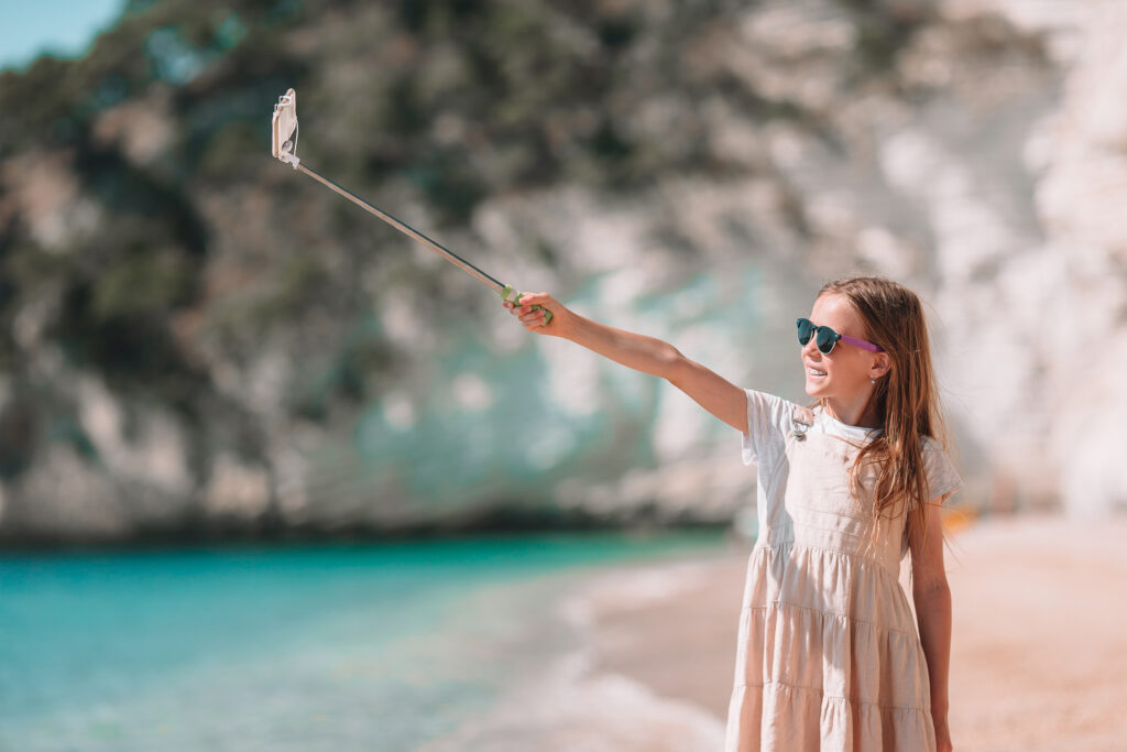 Little girl taking selfie by the seaside