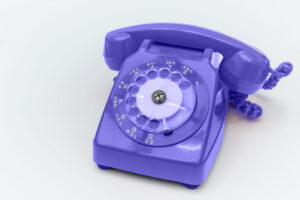 Purple Rotary telephone on white background.